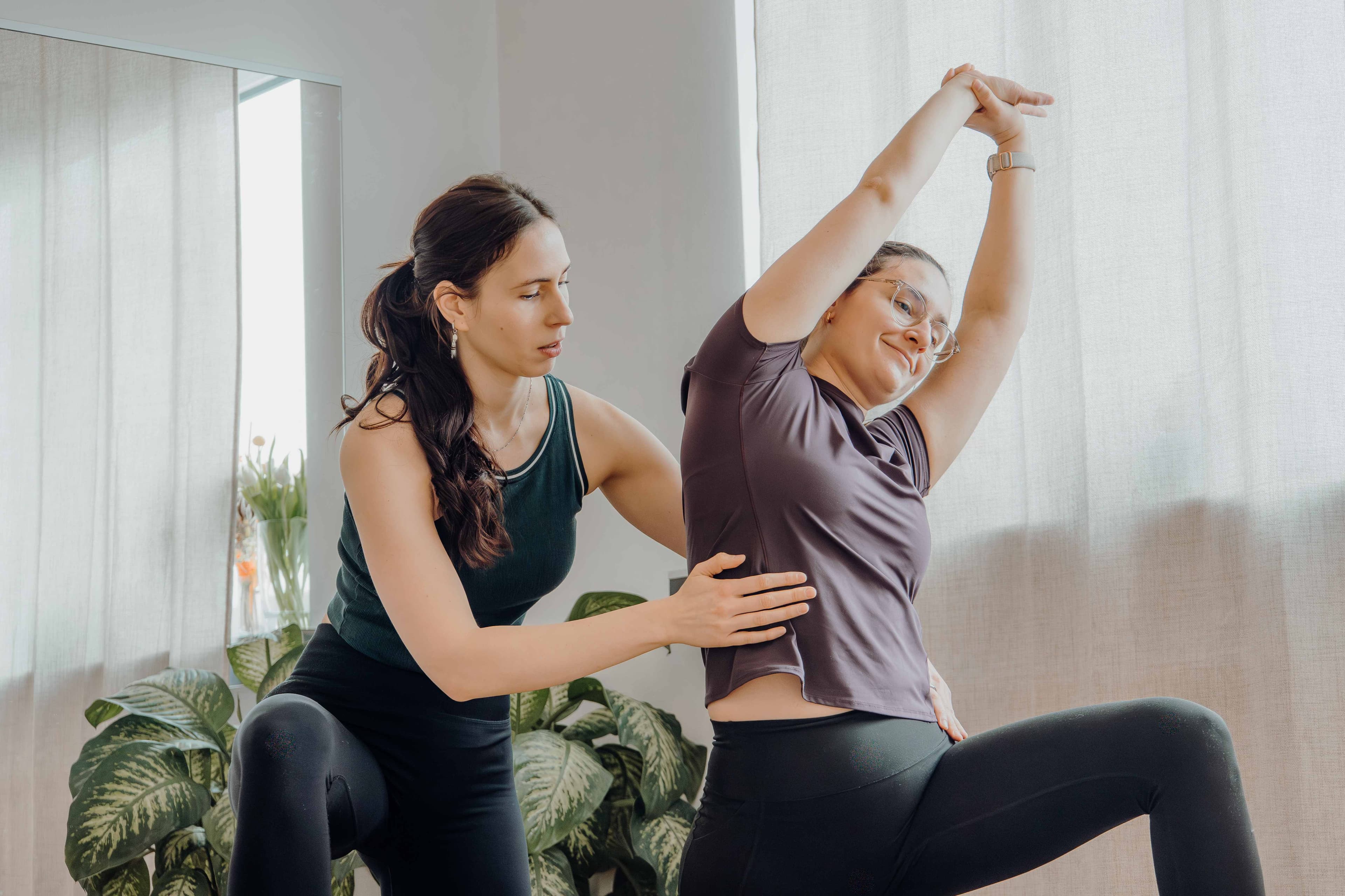 Therapeutin begleitet Patientin bei seitlicher Streckübung