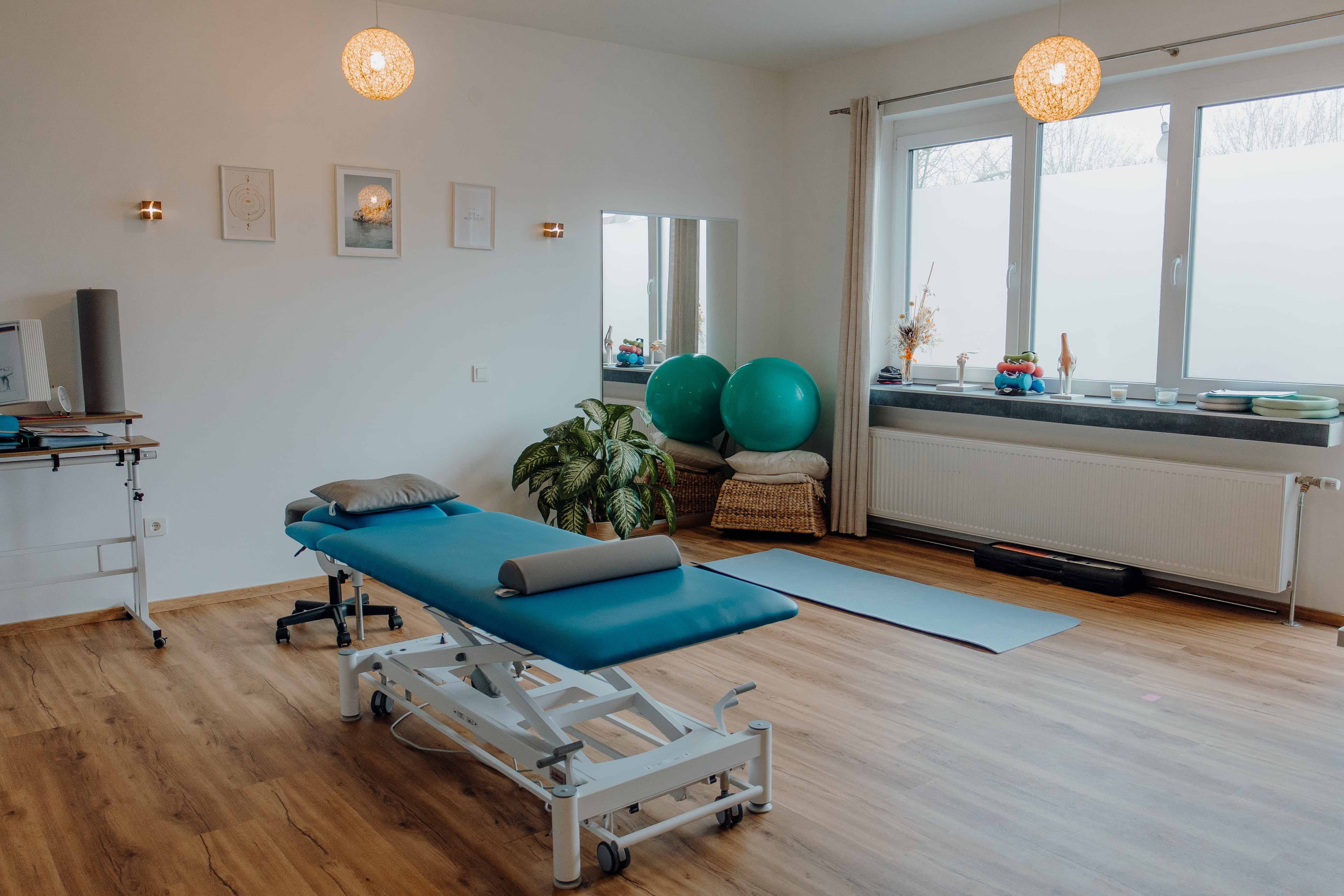 Behandlungsraum mit Gymnastikbaellen und warmer Beleuchtung